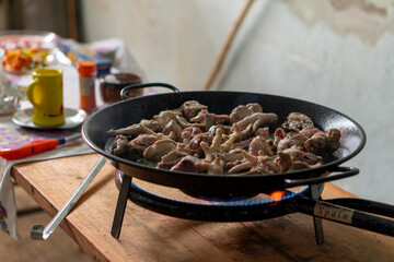 A pan of meat is cooking on a stove