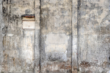 Weathered concrete wall with patched sections and vertical lines