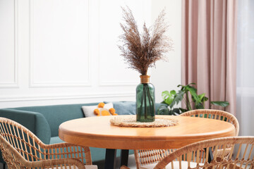 Wooden table with decor and stylish chairs in dining room, closeup
