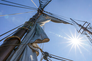 View of a historic sailing ship's mast and rigging, captured at Discovery Harbour, Penetanguishene, Ontario, under a clear blue sky.