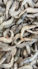Fototapeta premium Frozen shrimp closeup showing raw seafood texture, ideal for culinary backgrounds and recipes