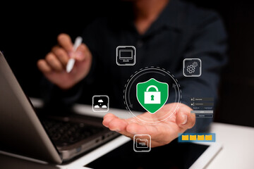 A person holds a digital shield symbolizing cybersecurity, surrounded by icons representing various tech elements, emphasizing data protection.