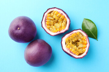 Fresh passion fruits with green leaf on light blue background, flat lay