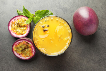 Tasty passion fruit drink with mint and fresh fruits on grey table, flat lay