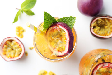 Tasty passion fruit drink with mint in glasses and fresh fruits on white table, flat lay