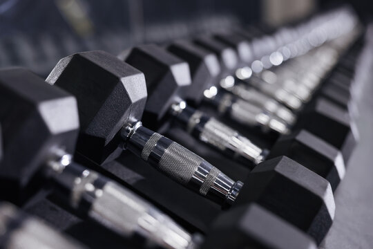 Different dumbbells in gym, closeup. Sport equipment - Powered by Adobe