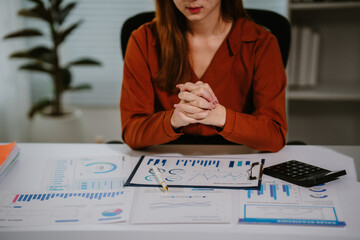 Young beautiful asian businesswoman holding unofficial spreadsheet paper accounting documents...
