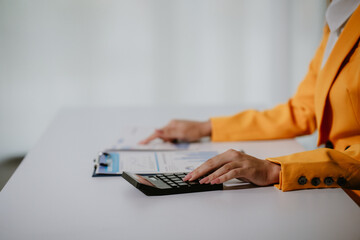 Young beautiful asian businesswoman holding unofficial spreadsheet paper accounting documents...