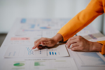 Young beautiful asian businesswoman holding unofficial spreadsheet paper accounting documents...