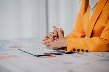 Young beautiful asian businesswoman holding unofficial spreadsheet paper accounting documents...
