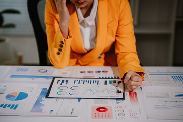 Young beautiful asian businesswoman holding unofficial spreadsheet paper accounting documents...