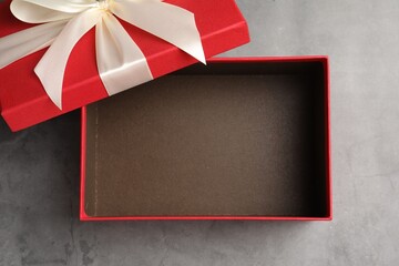 Opened gift box with beautiful lid on grey table, top view