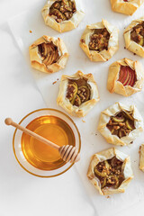 Rustic Fruit Galettes with Honey and Nuts on White Background. Top view
