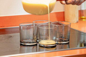 Preparation of vanilla flan with scraped vanilla beans, showing the process of beating eggs and condensed milk in a stainless steel bowl