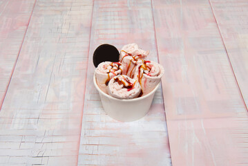 White chocolate ice cream tub with raspberries, white chocolate pieces, and raspberry sauce, garnished with fresh berries and mint