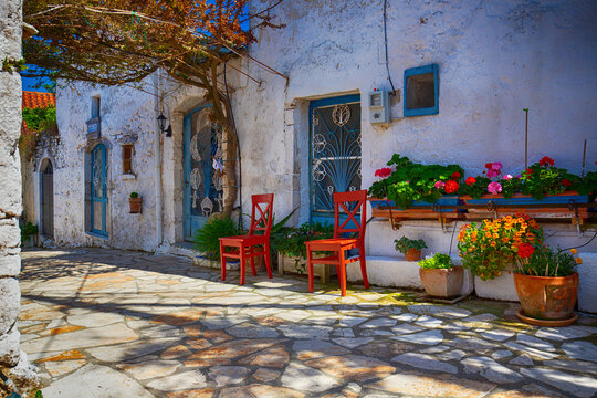 Fototapeta Narrow street in the old village of Afionas, surrounded by white architecture, on the Greek island of Corfu, background or wallpaper for a project