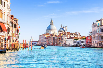 Amazing view of Basilica Santa Maria della Salute and Grand Canal with palaces, gondolas and boats  during sunset in Venice, Italy. Architecture and landmarks of Venice and Italy.