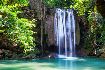 Beautiful Erawan waterfall in the dense tropical forest of Kanchanaburi Province, Thailand. Amazing waterfall with emerald lake in Erawan National Park in Kanchanaburi, Thailand.