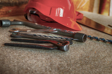 Red helmet and various tools lie on a neutral background