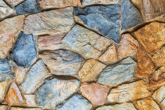 bright texture stone wall of different stones lying tightly