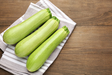 Fresh ripe zucchinis on wooden table, top view. Space for text