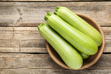 Fresh ripe zucchinis on wooden table, top view. Space for text