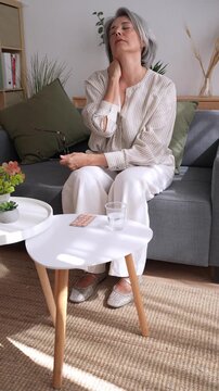 Senior woman suffering neck pain at home