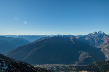 vista panoramica di un ambiente naturale tra le montagne italiane alpine in alta quota, in Friuli Venezia Giulia, vicino a Paularo, di giorno, con cielo sereno ed azzurro, in autunno