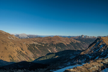 vista panoramica di un ambiente naturale tra le montagne italiane alpine in alta quota, in Friuli Venezia Giulia, vicino a Paularo, di giorno, con cielo sereno ed azzurro, in autunno