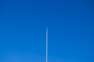 scia bianca di un aereo di linea alto nel cielo sereno e di un  azzurro intenso, di giorno