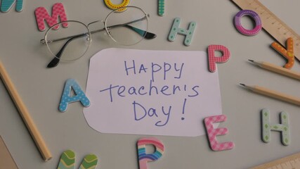 Colorful letters and stationery surround a handwritten note celebrating Happy Teacher's Day, showcasing a joyful and creative atmosphere. Happy teacher's day