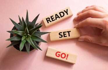 Ready Set Go symbol. Concept words Ready Set Go on wooden blocks. Beautiful pink background with succulent plant. Businessman hand. Business and Ready Set Go concept. Copy space.