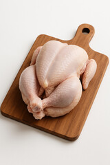 raw chicken on a wooden cutting board. Raw chicken on wooden cutting board on white background.