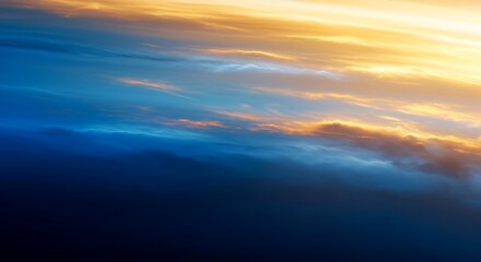 Fototapeta premium Dramatic sky with vibrant clouds at sunset or sunrise, blending blue and golden hues