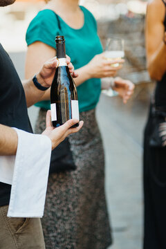 waiter with sparkling wine bottle