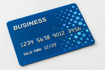 Close-up of blue business credit card with embossed numbers and dotted digital design, representing banking, corporate spending, financial transactions, online shopping, electronic payment systems.