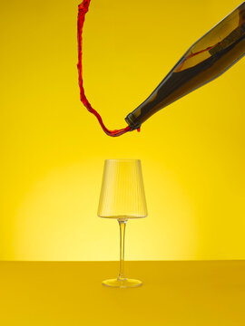 Red wine pouring upwards away from wine glass 