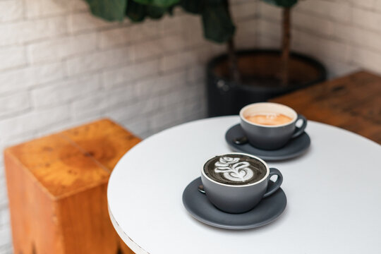 Sesame Latte and Empty Coffee Cup in a Cosy Cafe Corner With Greenery