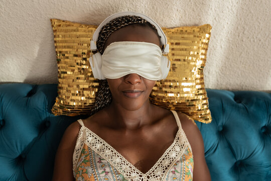 Woman relaxing in sleep mask and headphones