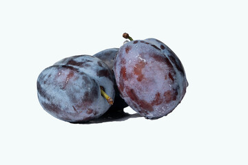 Fresh ripe plums covered with water droplets on white background