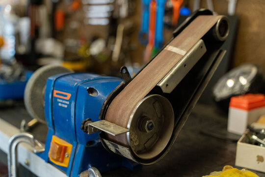 Belt sander resting on workbench in workshop