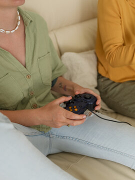 Woman playing video games at home with friend