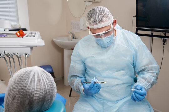 Dentist making local anesthesia shot before surgery. Patient visiting a dental office