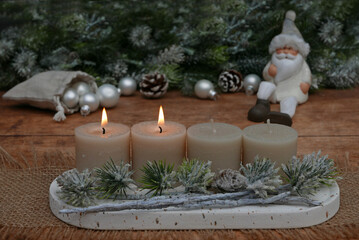 Adventsdekoration für den zweiten Advent : Dekoration mit vier Adventskerzen vor einer weihnachtlichen Kulisse mit Platz für Text.	