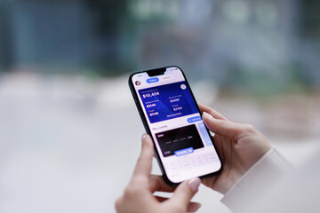 Anonymous woman checking credit card balance on smartphone