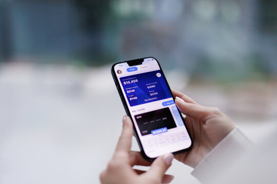 Anonymous woman checking credit card balance on smartphone