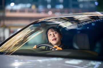 夜に車を運転する女性
