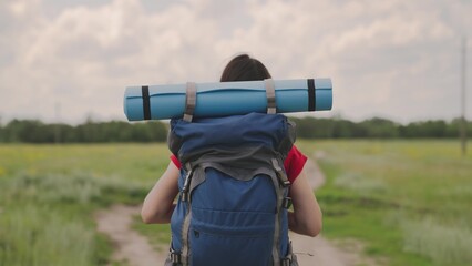 active girl with a backpack resting on a camping trip, a millennial traveler, hiking in nature,...