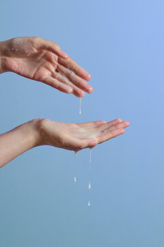 Hands Washing with Soap Lather and Pouring Liquid on Purple Background