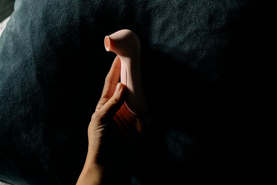 Hand holding a pink vibrator